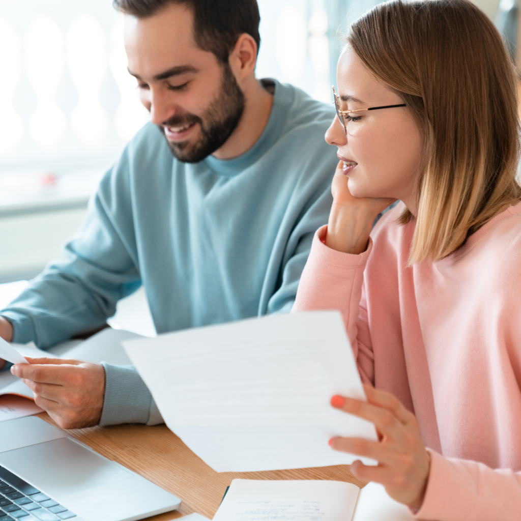 woman in glasses holding a paper looking at paper man is holding